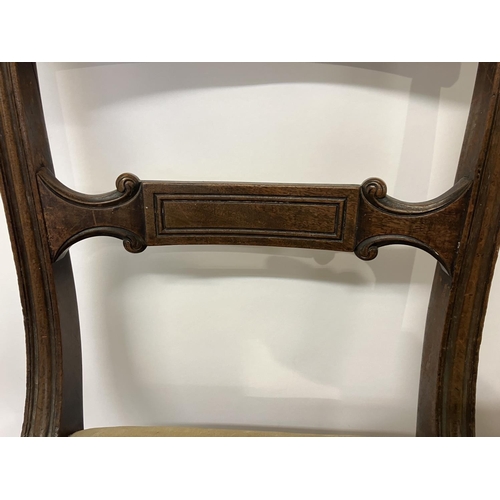 49 - In the manner of Gillows, a pair of Regency mahogany side chairs having curved top rail decorative b... 