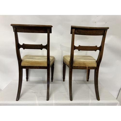 49 - In the manner of Gillows, a pair of Regency mahogany side chairs having curved top rail decorative b... 