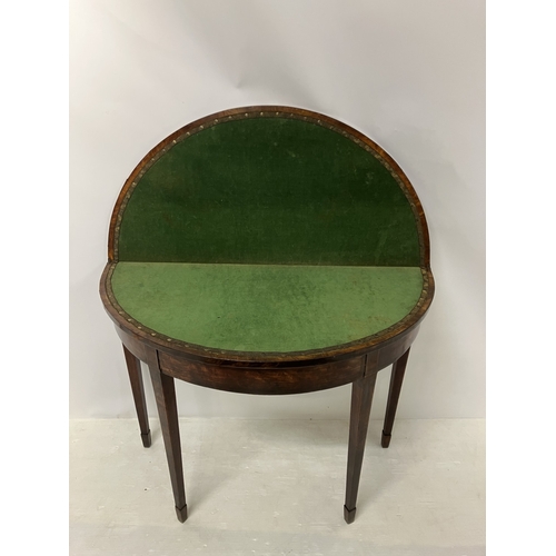 109 - A Georgian nicely figured mahogany demi lune card table, the fold over top with rosewood cross bandi... 