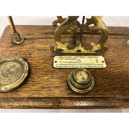 26 - A brass and oak postal scales with inland letter rates and a small Salter pocket balance. (2)