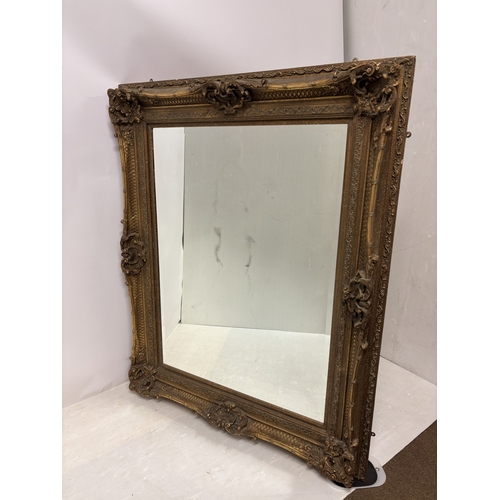 31 - A large modern gilt framed mirror. H. 160cm, W. 130cm. (2 black marks on the glass)