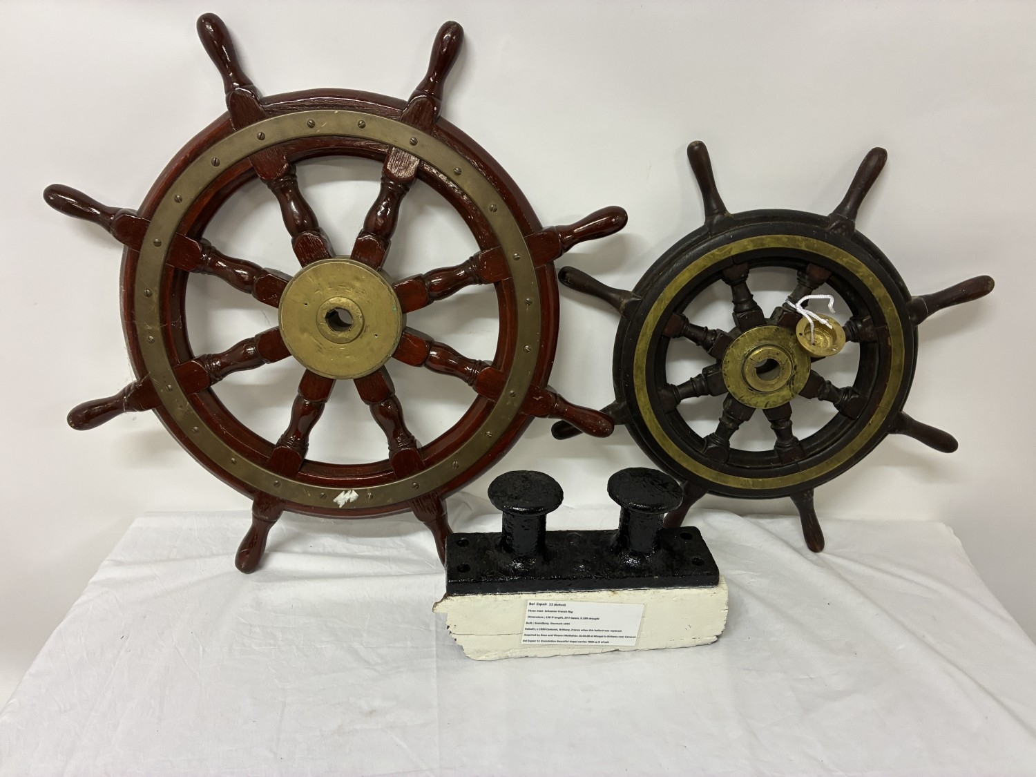 Two ships wheels & an iron deck fitting. (3)