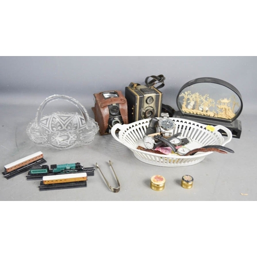 114 - A miscellaneous group of items to include cameras, watches, and a pair of silver sugar nips.