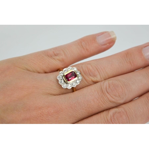 103 - An 18ct yellow gold, ruby and diamond ring, the cushion cut 1ct ruby bordered by 0.60cts, size N, 4.... 