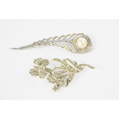 106 - A feather form brooch with pearl embellishment, an orchid form brooch set with marcasite, 7cm high.