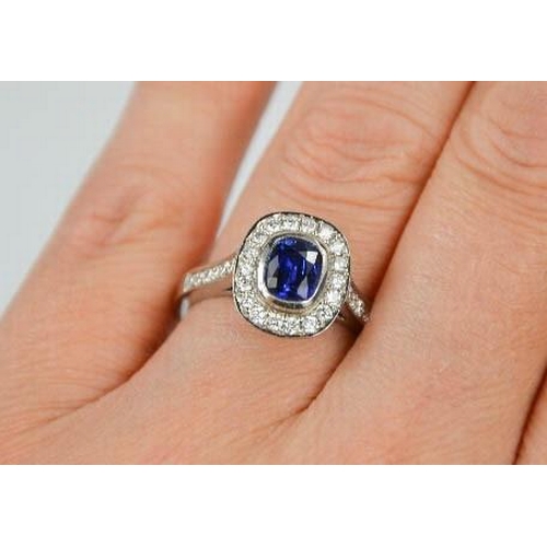 107 - An 18ct white gold sapphire and diamond ring, the sapphire approximately 0.90ct, the diamodns totall... 