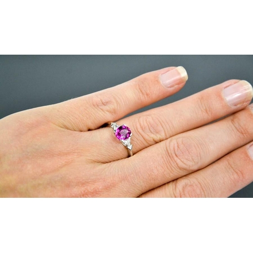 65 - An 18ct white gold, pink sapphire and diamond ring, the sapphire approximately 1ct, the diamonds 0.2... 