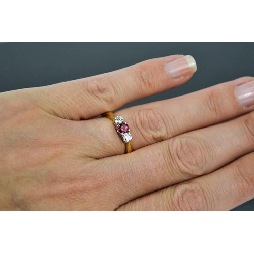 73 - An 18ct yellow gold, diamond and garnet trilogy ring, the central garnet flanked by diamonds, size M... 