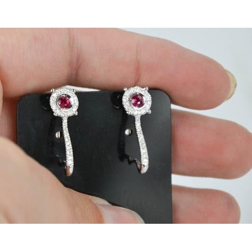 79 - An 18ct white gold, ruby and diamond earrings, the rubies totalling approximately 0.3ct, the diamond... 