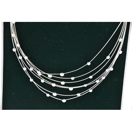 95 - An 18ct white gold, seven strand diamond set necklace, with thirty five individual collet set diamon... 