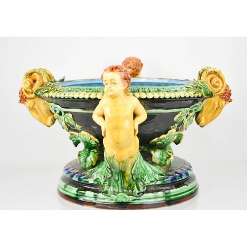 5 - A 20th century majolica jardinere with cherub head handles interspersed with rams heads,.