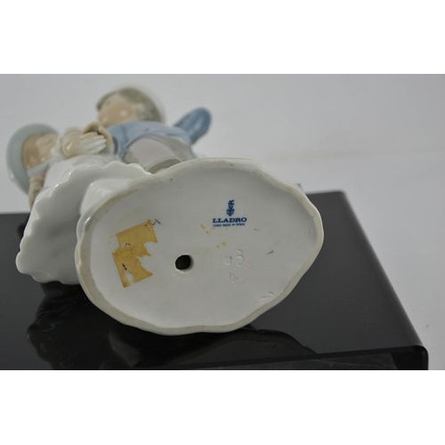 114 - A Lladro porcelain figure group titled Puppy Love; boy and girl holding hands, number 1127, 25cm hig... 