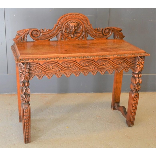 670 - A heavily carved green man mahogany side table, 96h by 107cm by 45cm