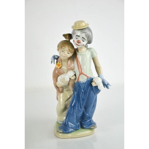 71 - A Lladro porcelain clown and girls with puppies, 7686, 23cm high.