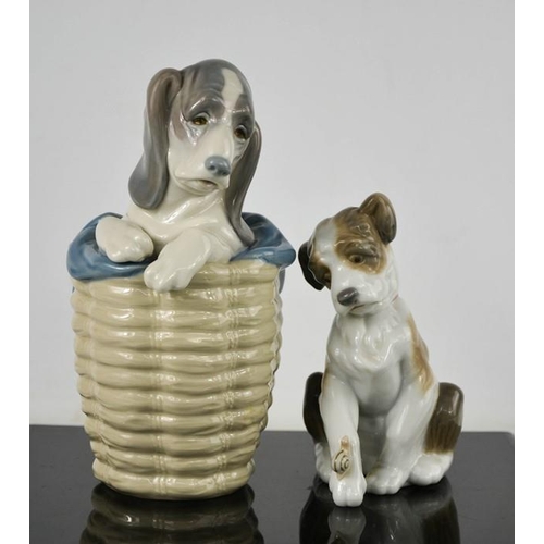 77 - A Lladro porcelain puppy in a basket, and another with a snail on his paw.