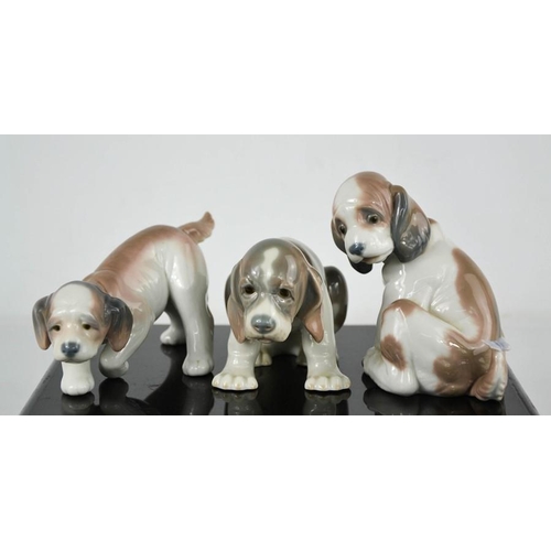 79 - Three Lladro porcelain figurines; each puppy in differing poses.