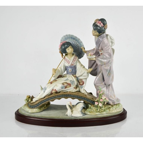 80 - A Lladro porcelain figure group titled Springtime in Japan, 1445, geisha girls on bridge, raised on ... 