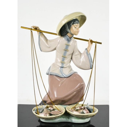 81 - A Lladro figure of girl with scales titled Fish a Plenty, 24cm high.