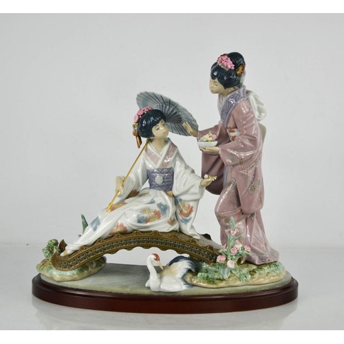 82 - A Lladro porcelain figure group titled Springtime in Japan, 1445, geisha girls on a bridge, raised o... 