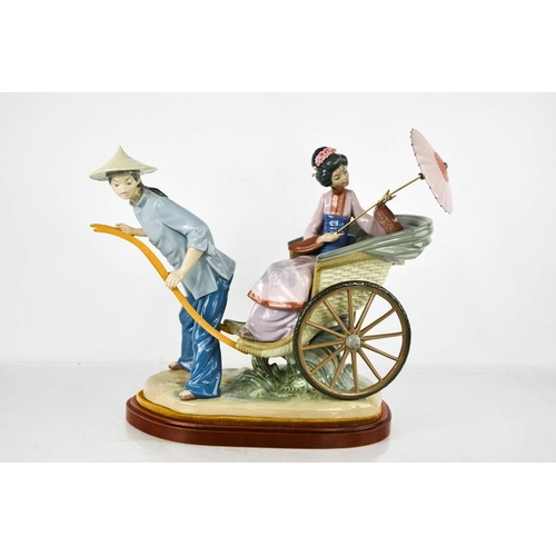 87 - A large Lladro porcelain figure group titled The Rickshaw Ride, no. 1383, raised on a wooden base, 3... 