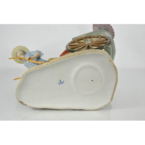 87 - A large Lladro porcelain figure group titled The Rickshaw Ride, no. 1383, raised on a wooden base, 3... 