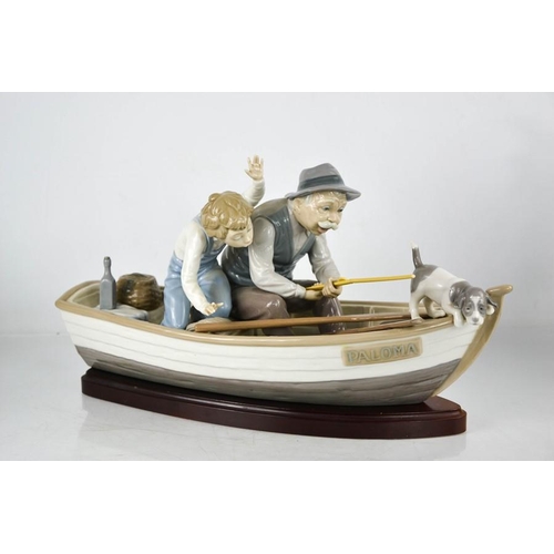 98 - A Lladro porcelain group titled Fishing with Gramps, on a boat named Paloma, with wooden stand.