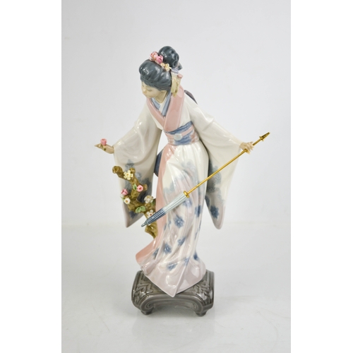 84 - A Lladro porcelain geisha girl holding an umbrella and picking flowers, 27cm high.