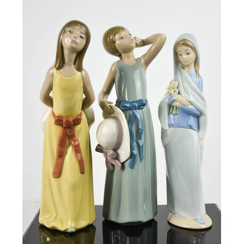 125 - Three Lladro porcelain figurines including with Girl with Calla Lilys, 24cm high.