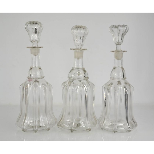 137 - Three moulded glass decanters with stoppers.