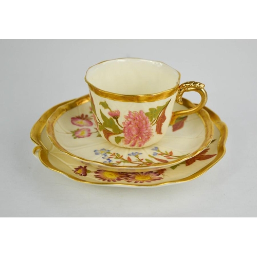 14 - A Royal Worcester trio of blush ivory and floral painted cup, saucer and plate with gilded handles a... 