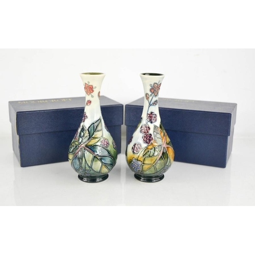 32 - A pair of Moorcroft vases, with the original boxes, signed J Moorcroft to the bases.