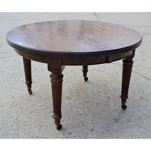 554 - A late 19th century mahogany dining table raised on tapering fluted legs and brass castors, with thr... 