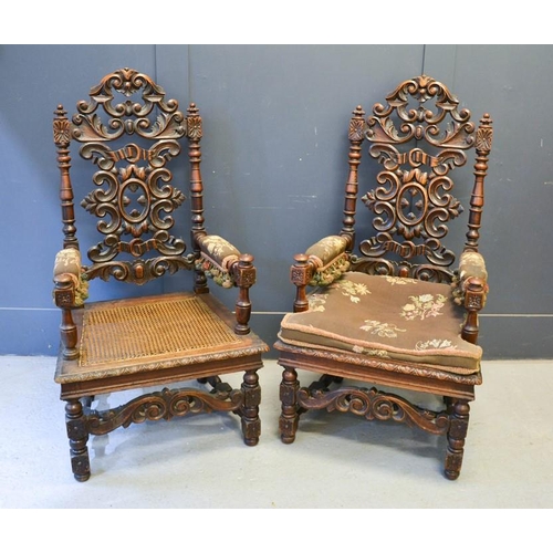 555 - A pair of 19th century oak throne style armchairs, with carved scrollwork back, upholstered arms and... 