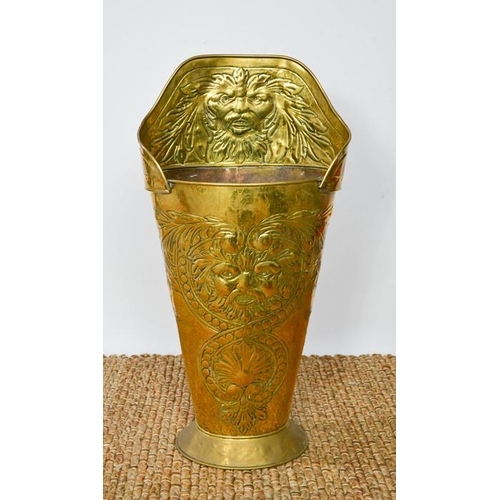 560 - A late 19th century brass stick umbrella stand, embossed with lion masks and shell decoration, of ta... 