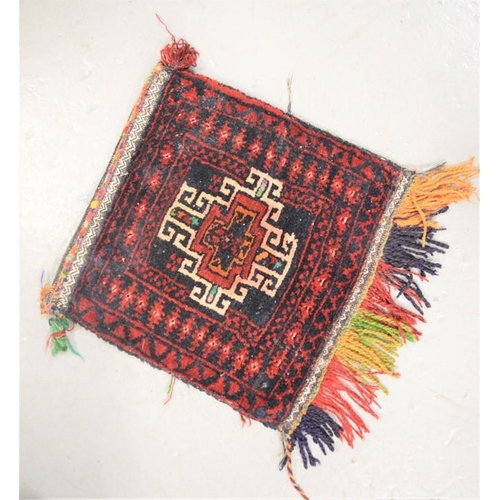 562 - An Afganistan Belouch bag with red ground, 1ft2 by 1ft2ins, together with another with brown ground ... 