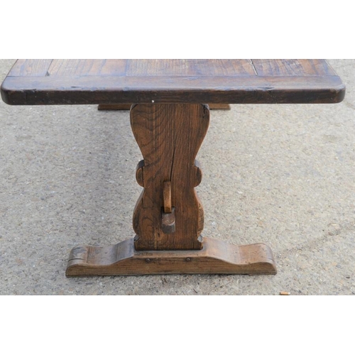 566 - An oak refrectory table, the planked top with cleated ends, raised on lyre form legs and central str... 