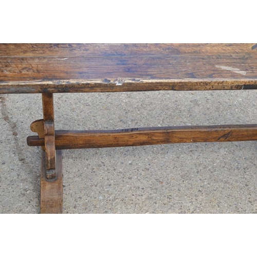 566 - An oak refrectory table, the planked top with cleated ends, raised on lyre form legs and central str... 