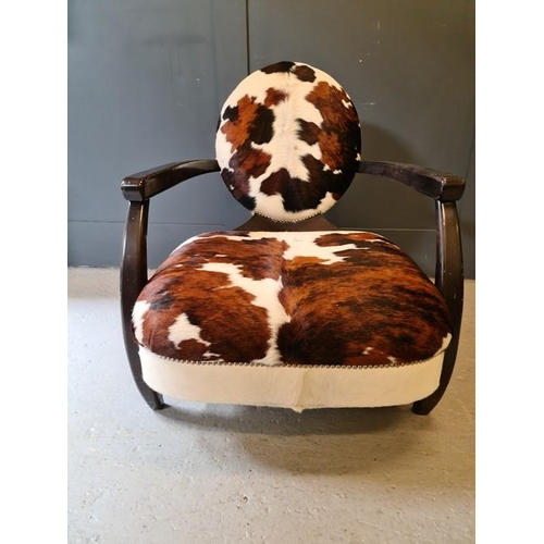 100 - Andrew Martin armchair upholstered in cow hide, with wooden frame and oval back.