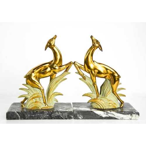 5 - A pair of Art Deco spelter leaping deer book ends, gilded and cold painted, raised on black and whit... 