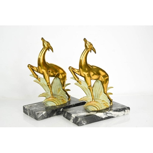 5 - A pair of Art Deco spelter leaping deer book ends, gilded and cold painted, raised on black and whit... 