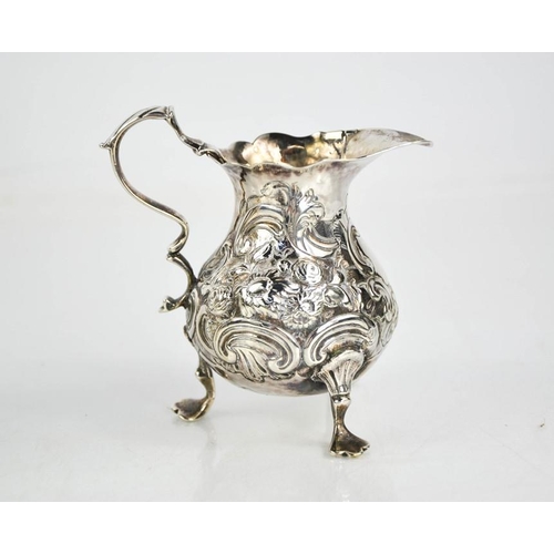 162 - A silver jug embossed with scrollwork, indistinct London hallmarks, initialled I G+A, 2.95toz.