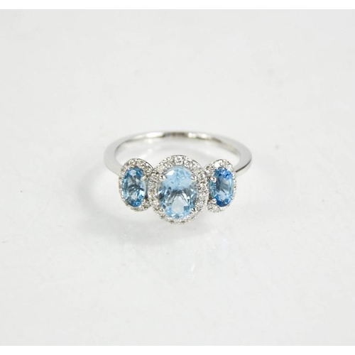 218 - An 18ct gold aquamarine and diamond trilogy ring, J½, 2.65g.