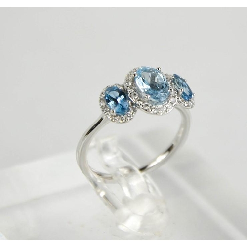 218 - An 18ct gold aquamarine and diamond trilogy ring, J½, 2.65g.