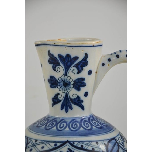 297 - An early 20th century delft blue and white jug of ovid form, embossed with flowers and bird motifs, ... 