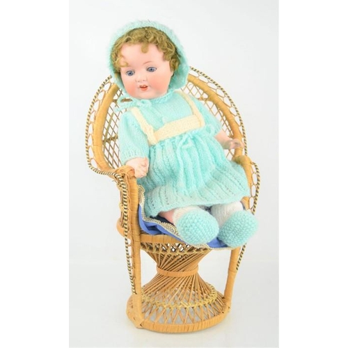 479 - An Armand Marseille bisque doll No 996 and a wicker chair