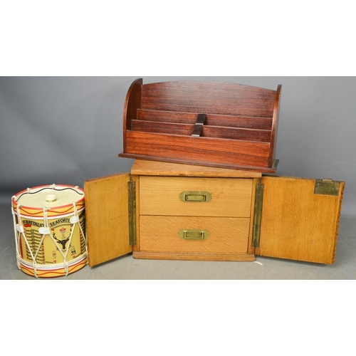 500 - An oak two drawer cabinet enclosed with doors, a letter rack and a Seaforth Highlanders drum form ic... 
