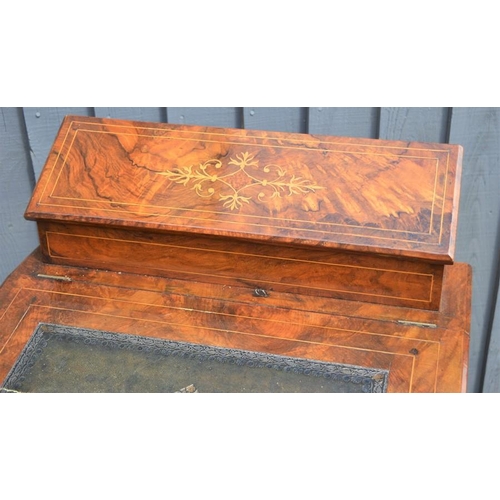 574 - A Victorian mahogany davenport with correspondence compartment over sloped front and two shaped tier... 