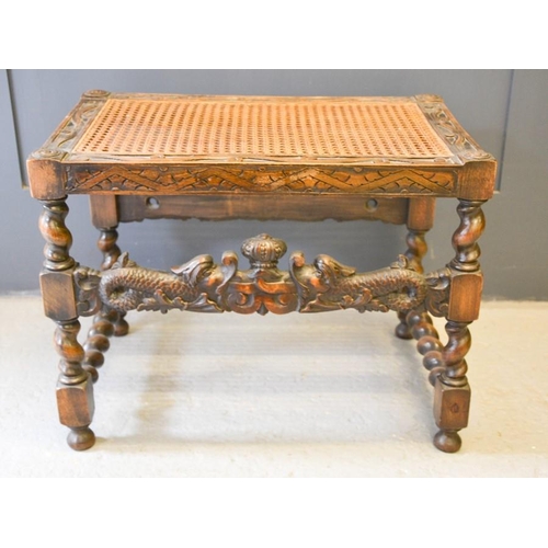 621 - A 19th century oak stool with carved dolphins and a crown and foliage to both fronts, with barleytwi... 