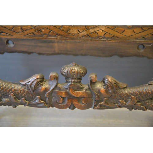 621 - A 19th century oak stool with carved dolphins and a crown and foliage to both fronts, with barleytwi... 