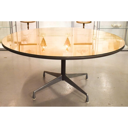 593 - A Herman Miller action office circular top table with a brushed chrome base comprised of four feet, ... 